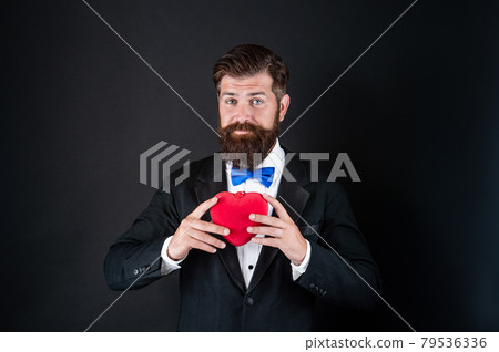 handsome man in tuxedo holding love gift of heart for valentines day, valentine 79536336