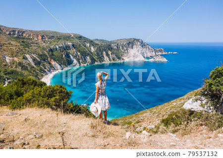 A tourist woman enjoying beautiful Petani beach on Kefalonia Ionian island, Greece, during her summer vacation holiday 79537132