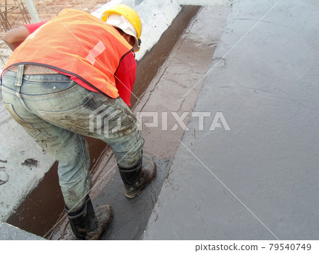 SELANGOR, MALAYSIA -SEPTEMBER 16, 2014: Construction worker apply layers of bituminous waterproofing at the building roof slab surface. SELANGOR, MALAYSIA -SEPTEMBER 16, 2014: Construction worker apply layers of bituminous waterproofing at the building roof slab surface. 79540749