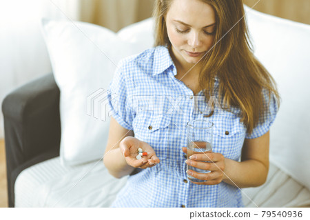 Close-up woman holding pills time to take medications, cure for headache, high blood pressure or cholesterol level remedy pain killer drugs. Medicine concept 79540936