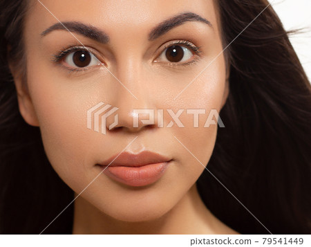 Closeup of beauty women with clean skin, full lips and long dark hair. Looks at the camera and shows skin care. Increased skin texture around the eyes and lips. Smile on face 79541449