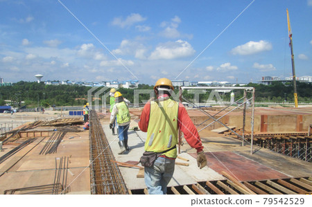 MALACCA, MALAYSIA -SEPTEMBER 24, 2016: Construction workers fabricating floor slab reinforcement bar at the construction site in Malacca, Malaysia. MALACCA, MALAYSIA -SEPTEMBER 24, 2016: Construction workers fabricating floor slab reinforcement bar at the construction site in Malacca, Malaysia. 79542529
