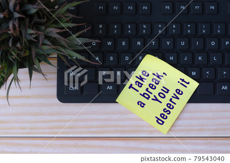 Text on yellow note with keyboard and potted plant on wooden table Text on yellow note with keyboard and potted plant on wooden table 79543040