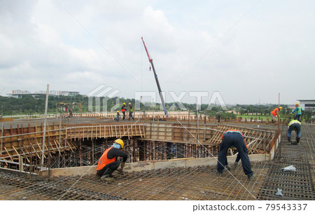 MALACCA, MALAYSIA -SEPTEMBER 24, 2016: Construction workers fabricating floor slab reinforcement bar at the construction site in Malacca, Malaysia. MALACCA, MALAYSIA -SEPTEMBER 24, 2016: Construction workers fabricating floor slab reinforcement bar at the construction site in Malacca, Malaysia. 79543337