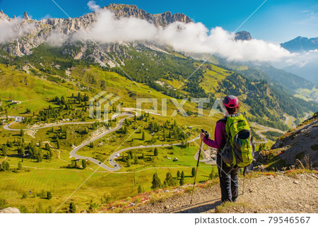 Active hiker hiking, enjoying the view, looking at Dolomites mountains landscape Active hiker hiking, enjoying the view, looking at Dolomites mountains landscape 79546567
