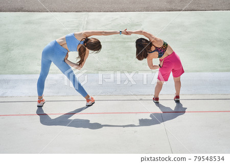 Girls training at fresh air at morning with concentrated emotions while making slopes Girls training at fresh air at morning with concentrated emotions while making slopes 79548534