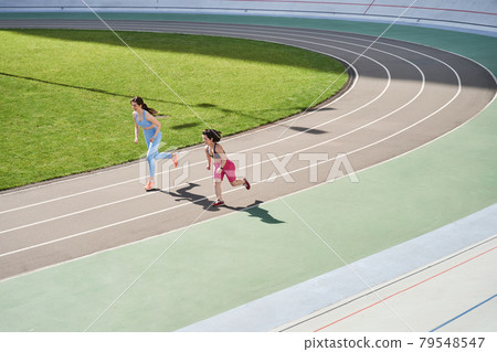 Two happy girls running with each other at the morning Two happy girls running with each other at the morning 79548547