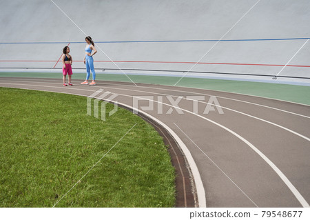 Couple of friends standing and having conversation Couple of friends standing and having conversation 79548677