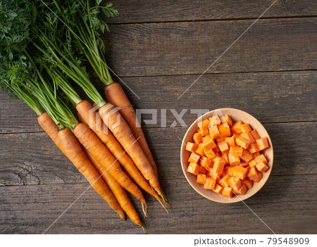 dice carrots in a wooden bowl on a table, top view, copy space for text. dice carrots in a wooden bowl on a table, top view, copy space for text. 79548909