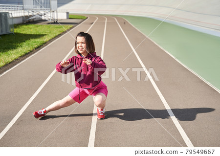 Woman with short hair playing sports in the stadium and warming up for sports Woman with short hair playing sports in the stadium and warming up for sports 79549667