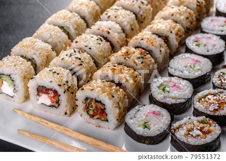 Delicious fresh rolls in various sets. Japanese food with avocado, shrimp, crab and salmon 79551372