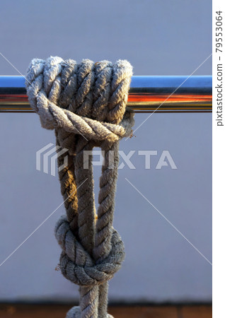 Rope knot tied to railing. Rope knot tied to railing. 79553064