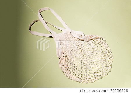 Reusable cotton shopping string bag on green background. Zero waste concept. No plastic Reusable cotton shopping string bag on green background. Zero waste concept. No plastic 79556308