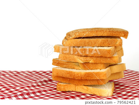 sliced bread on red checked tablecloth background 79562421