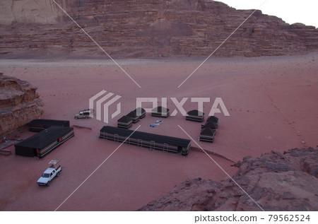 [Jordan] A vast desert Wadiram, a black tent of a nomadic Bedouin built in the shade of a rock, and a white four-wheel drive that stops. 79562524
