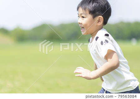 4-year-old boy running around the lawn 79563084