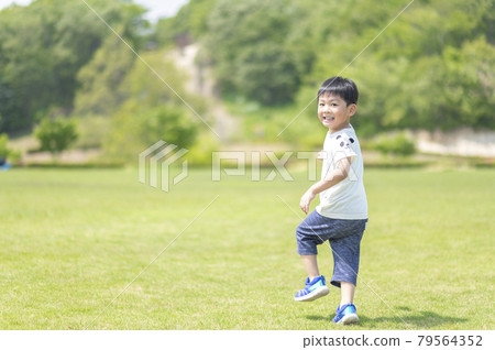 4-year-old boy running on the lawn 79564352