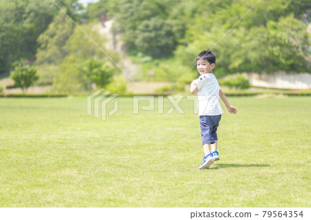 4-year-old boy running on the lawn 79564354