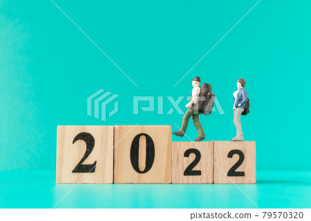 Miniature people : backpacker and tourist standing on wooden block number 2022 Miniature people : backpacker and tourist standing on wooden block number 2022 79570320