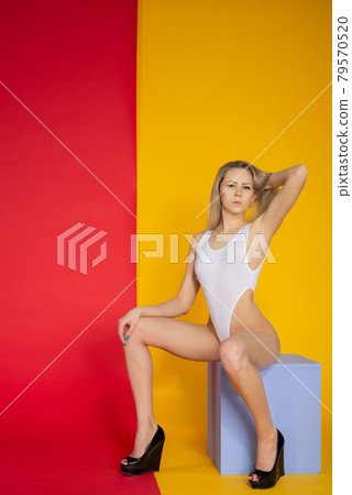 beautiful sexy slim woman with perfect body in white bodysuit posing on background 79570520