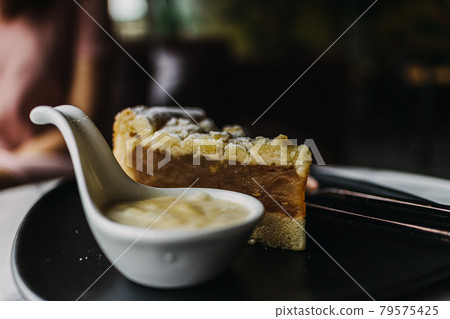 Close up of Apple Crumble Cake in dark classic cafe. 79575425