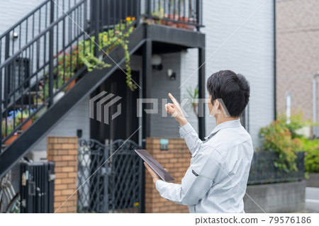 Young male worker doing house inspection work Young male worker doing house inspection work 79576186