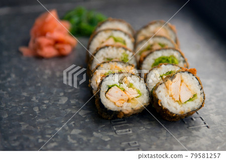 Sushi meal with ginger and wasabi on a metal plate. Sushi Set - Different Types of Maki Sushi and Nigiri. Restaurant menu with fish food. 79581257