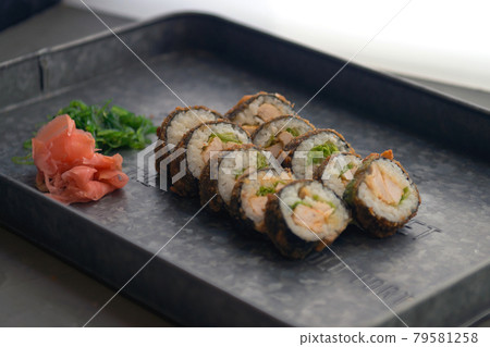 Sushi meal with ginger and wasabi on a metal plate. Sushi Set - Different Types of Maki Sushi and Nigiri. Restaurant menu with fish food. 79581258