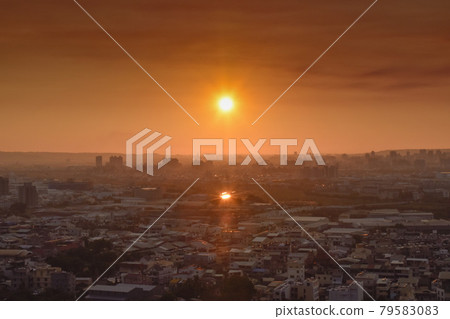 城市上空瀰漫著陰霾，陽光反射在屋頂上，火雲特別，浪漫美麗。 79583083