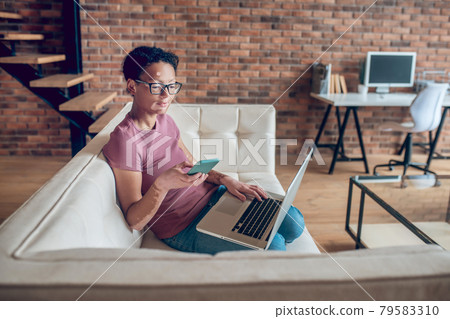 A woman in eyeglasses holding a smartphone 79583310