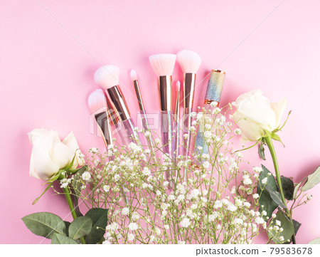 Trendy make up brushes with products on pink background with gypsophila flowers Trendy make up brushes with products on pink background with gypsophila flowers 79583678