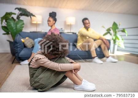 Unhappy little girl and sad parents at home 79583710