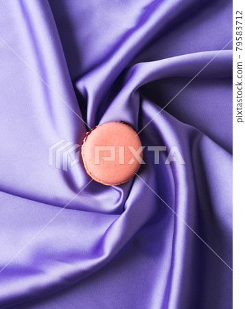 Pastel pink french macaroons on purple silk fabric background 79583712