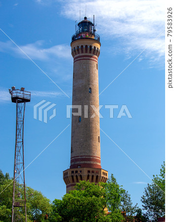 Swinoujscie. Old stone lighthouse on a background of blue sky. Swinoujscie. Old stone lighthouse on a background of blue sky. 79583926