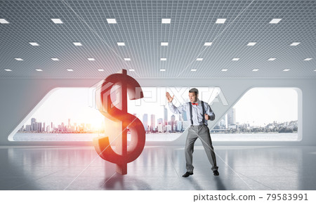 Determined banker man in modern office interior breaking dollar figure 79583991