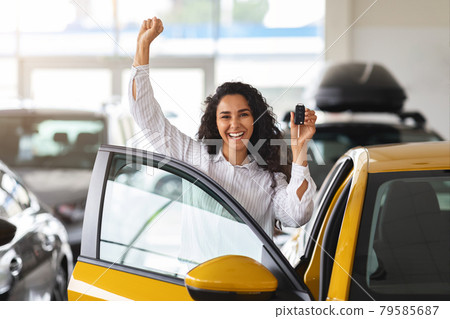 Emotional brunette woman buying new car, showroom interior Emotional brunette woman buying new car, showroom interior 79585687