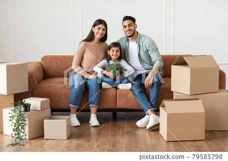Positive young family looking at camera, posing in new apartment Positive young family looking at camera, posing in new apartment 79585798