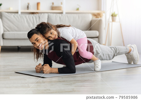 Happy sporty father and kid bonding while training at home Happy sporty father and kid bonding while training at home 79585986