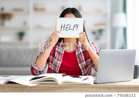 Female Student Holding Leaflet With Drawn Help Word In Front Of Face Female Student Holding Leaflet With Drawn Help Word In Front Of Face 79586132