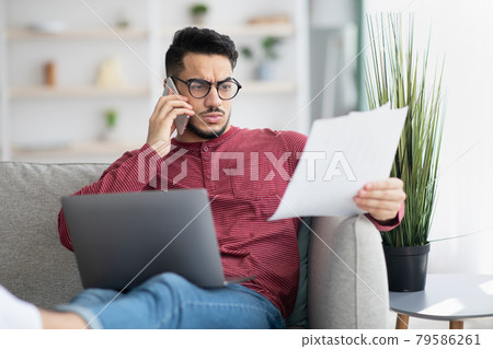 Middle-eastern businessman working from home, having phone conversation 79586261