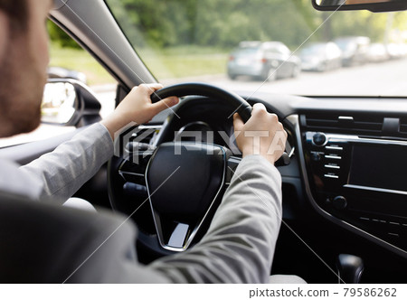 Personal transport, health care, man driving car, hand on steering wheel, looking at road ahead 79586262