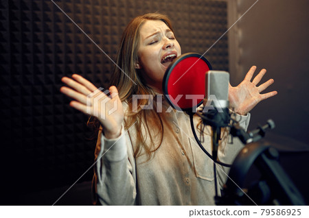 Female performer at micriphone, recording studio 79586925