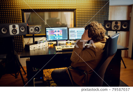 Male sound engineer at mixing consol, back view 79587037