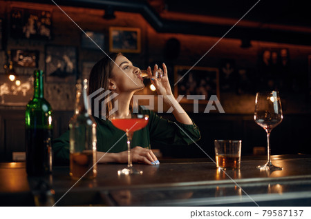 Stressed woman drinks alcohol at counter in bar 79587137