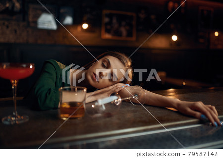 Drunk young woman sleeping at the counter in bar 79587142