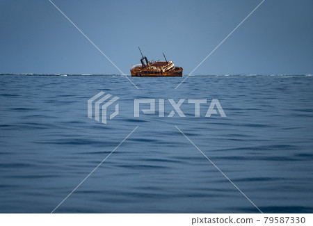 Sink wrecked ship lie down in middle of the sea, rusty and old. Sink wrecked ship lie down in middle of the sea, rusty and old. 79587330