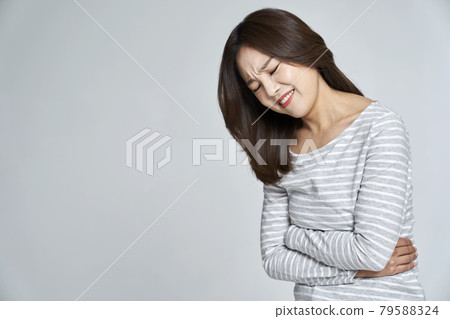abdominal pain, menstruation, menstrual cramps, pain, young woman, nukki, gray background 79588324