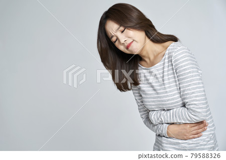 abdominal pain, menstruation, menstrual cramps, pain, young woman, nukki, gray background 79588326