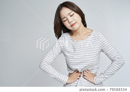 abdominal pain, menstruation, menstrual cramps, pain, young woman, nukki, gray background abdominal pain, menstruation, menstrual cramps, pain, young woman, nukki, gray background 79588334