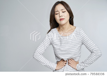 abdominal pain, menstruation, menstrual cramps, pain, young woman, nukki, gray background 79588336